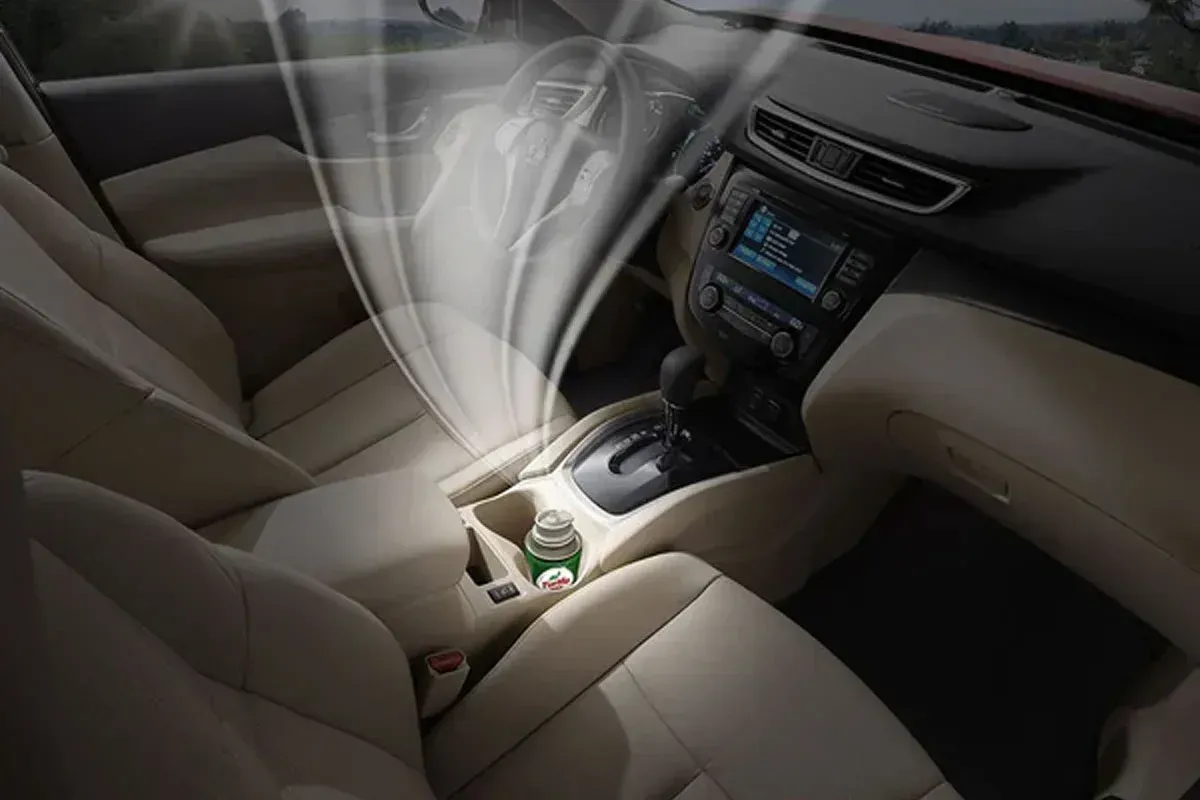 The interior of a car with a bottle of water in the center console.