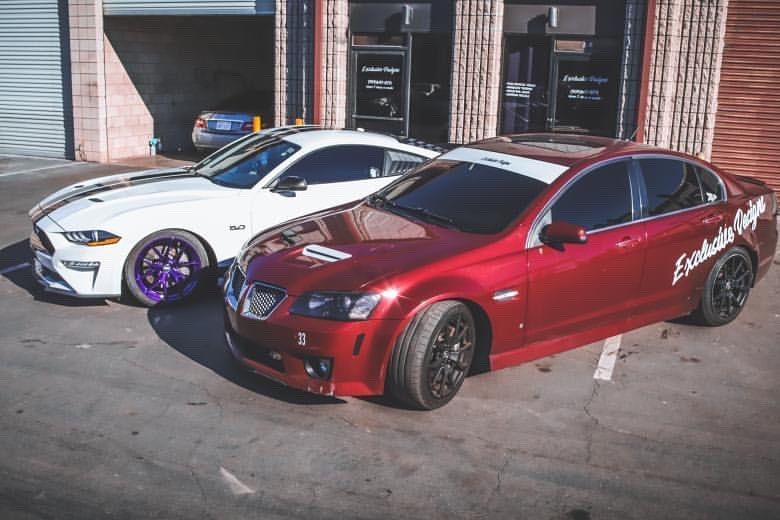 Two cars are parked next to each other in front of a building.