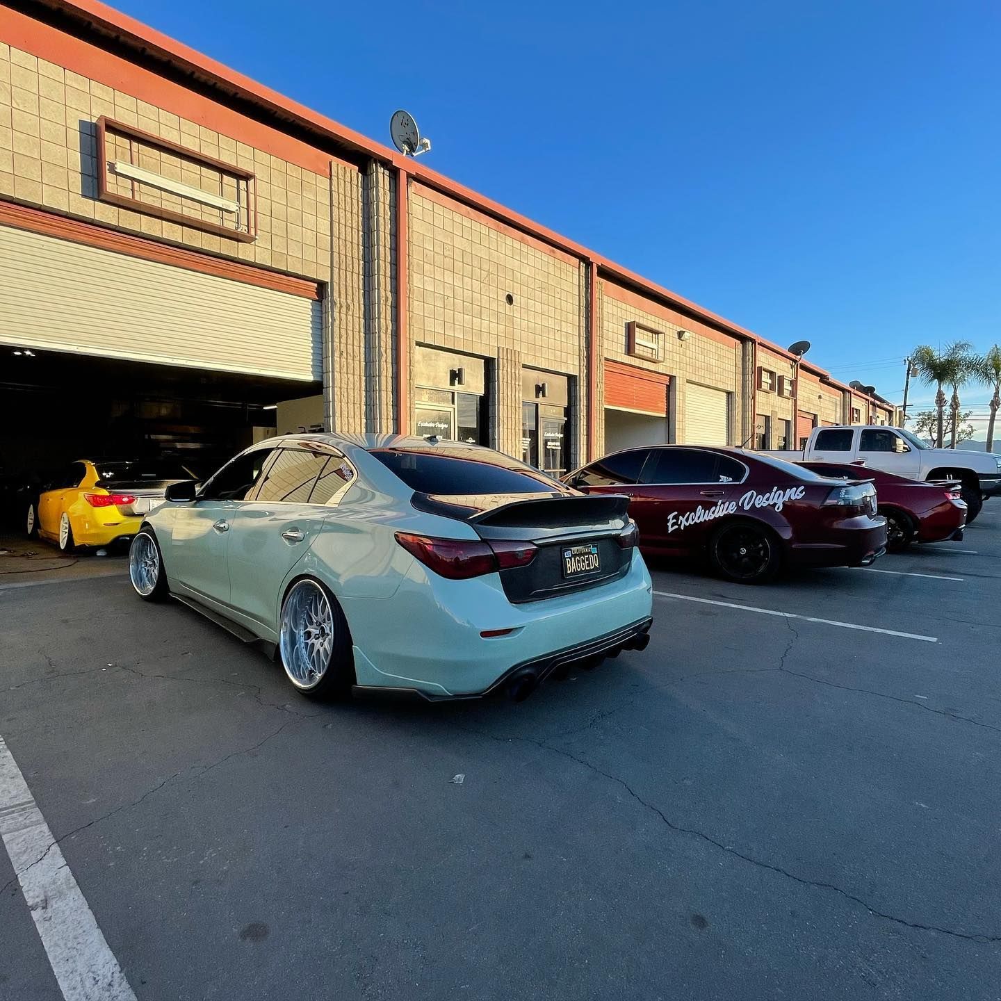 A row of cars are parked in front of a building.
