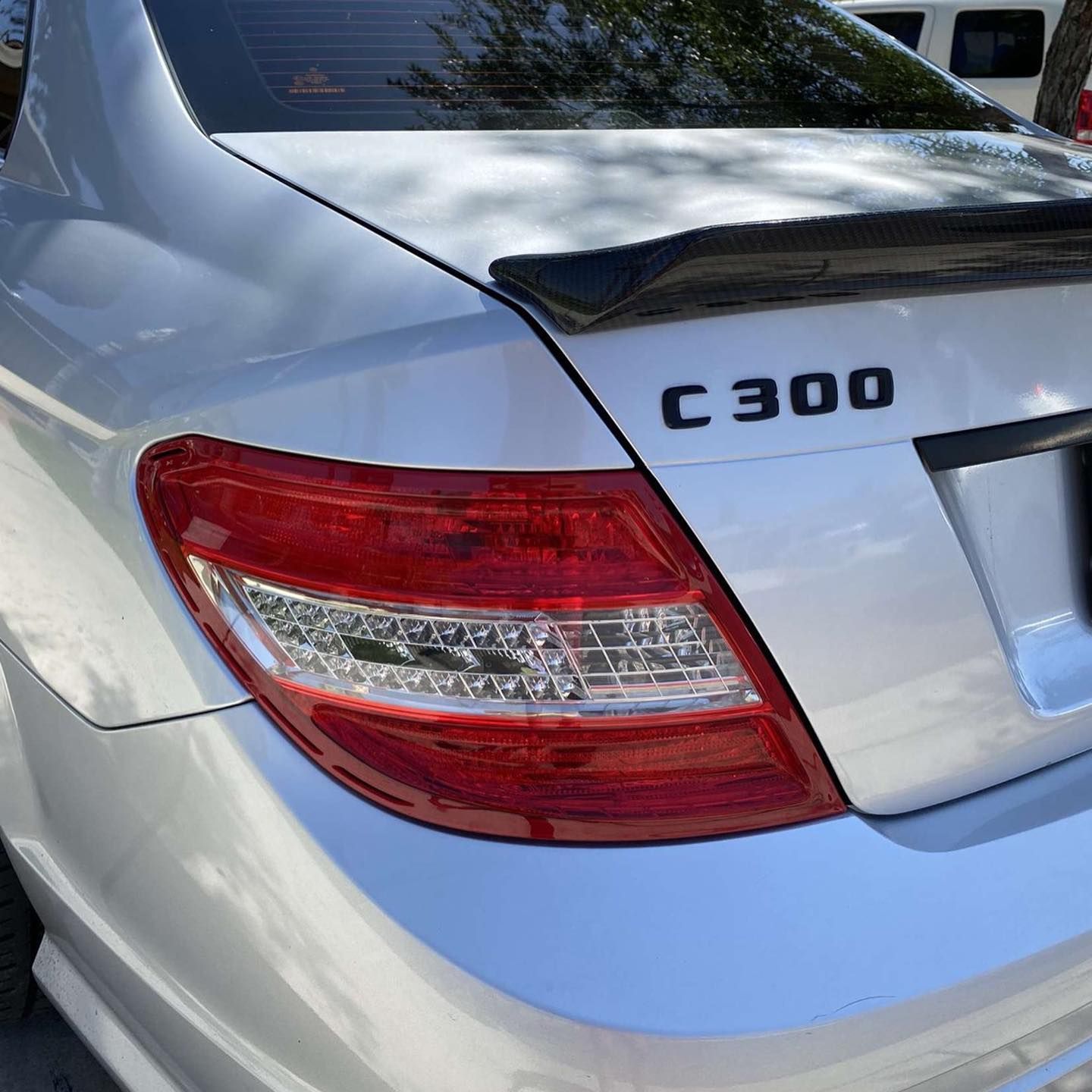 A silver mercedes c300 is parked in a parking lot