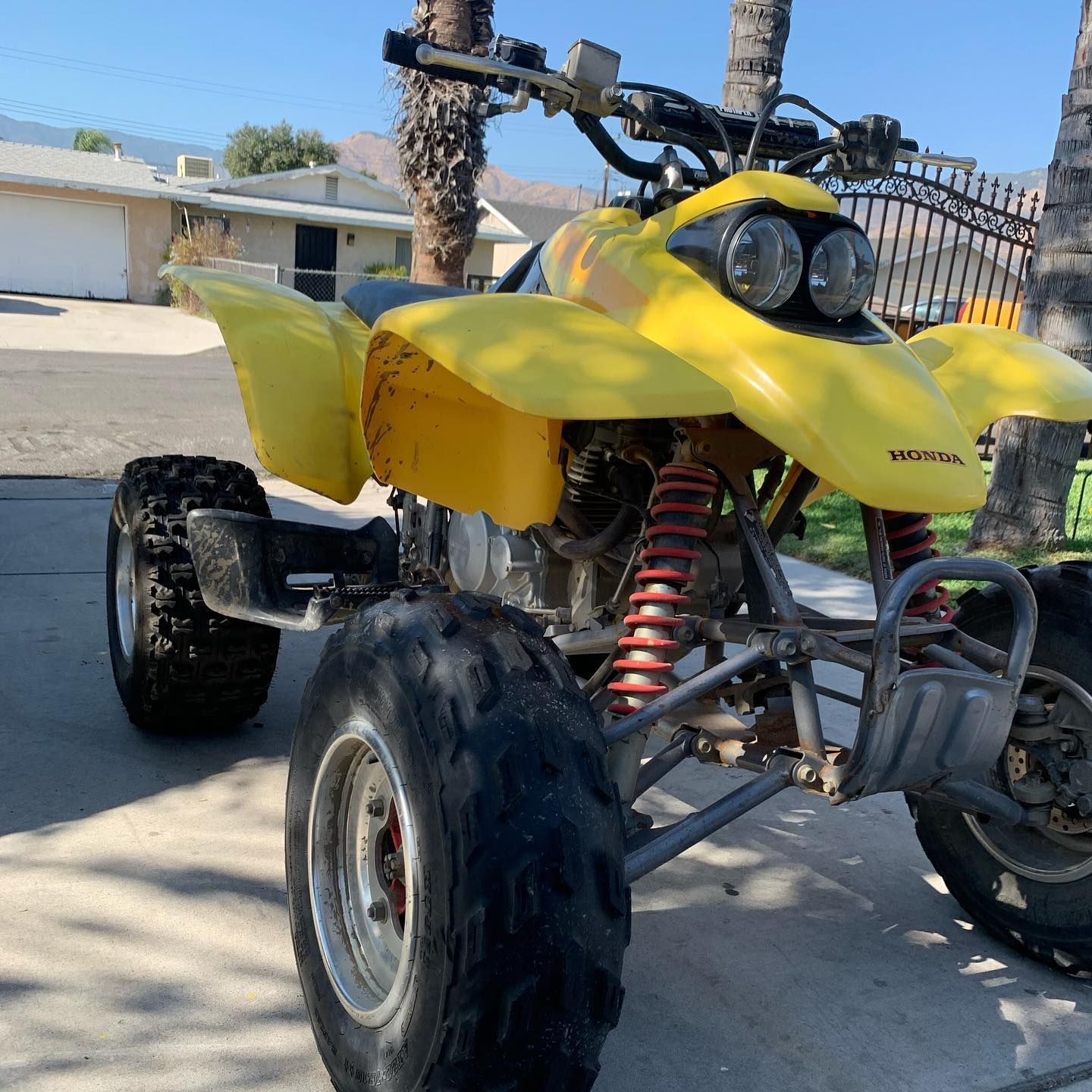 A yellow atv is parked on the side of the road