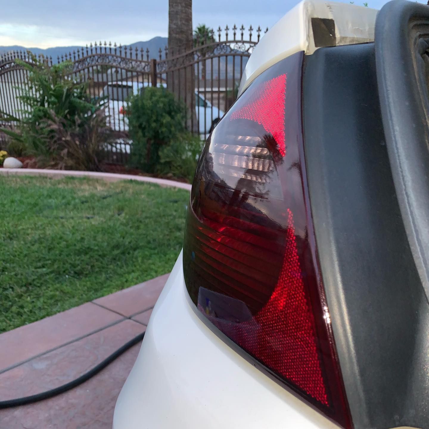 The back of a white car with a red tail light