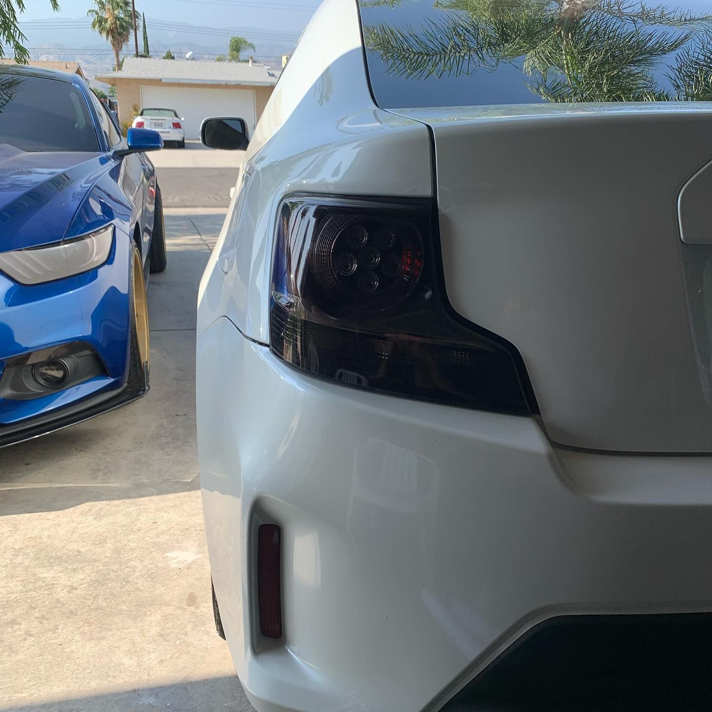 A blue car is parked next to a white car
