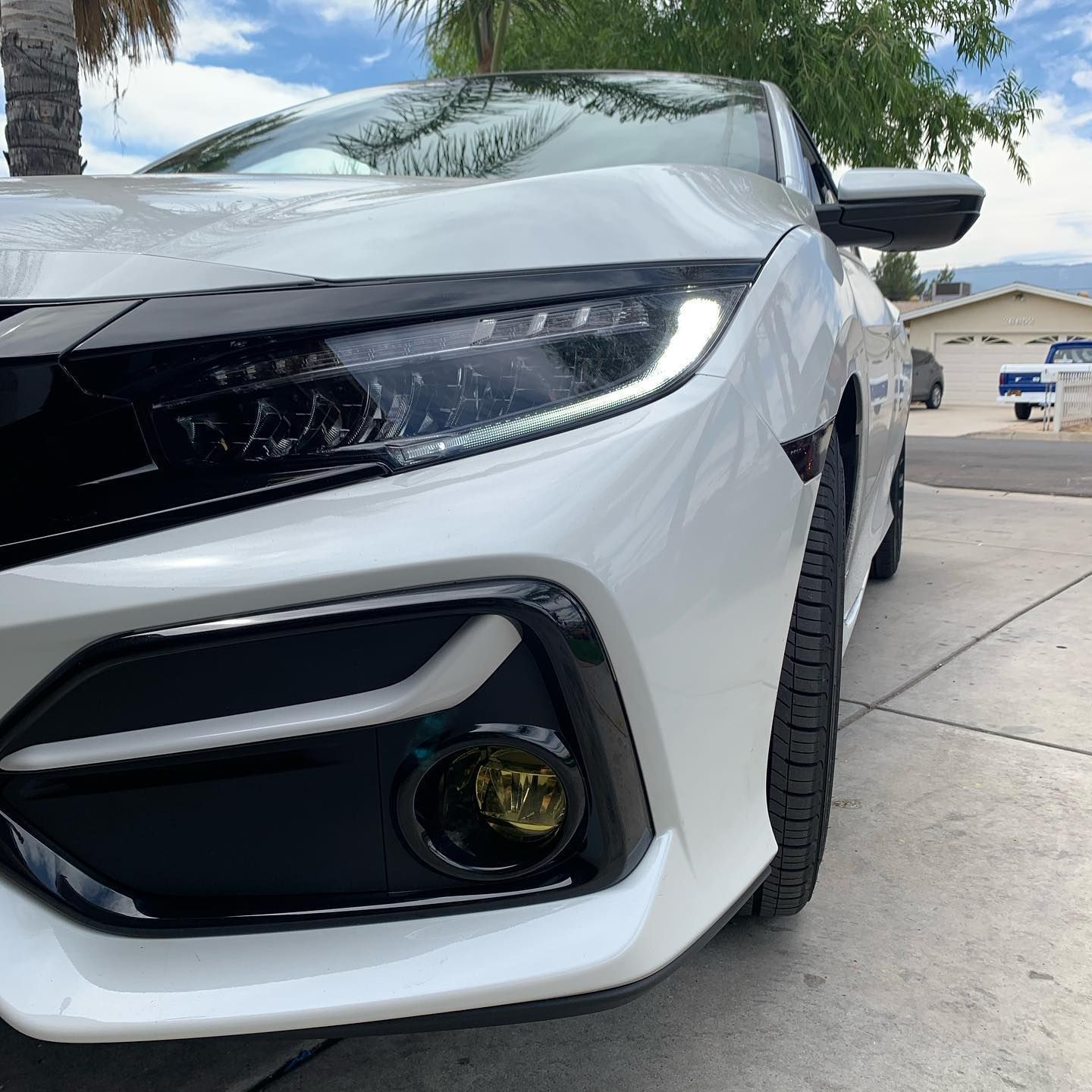 A white car is parked on the side of the road