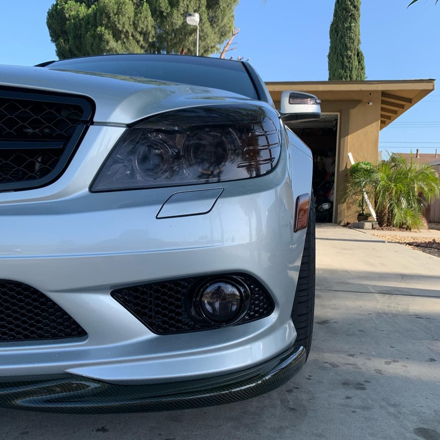 A silver car is parked in front of a garage