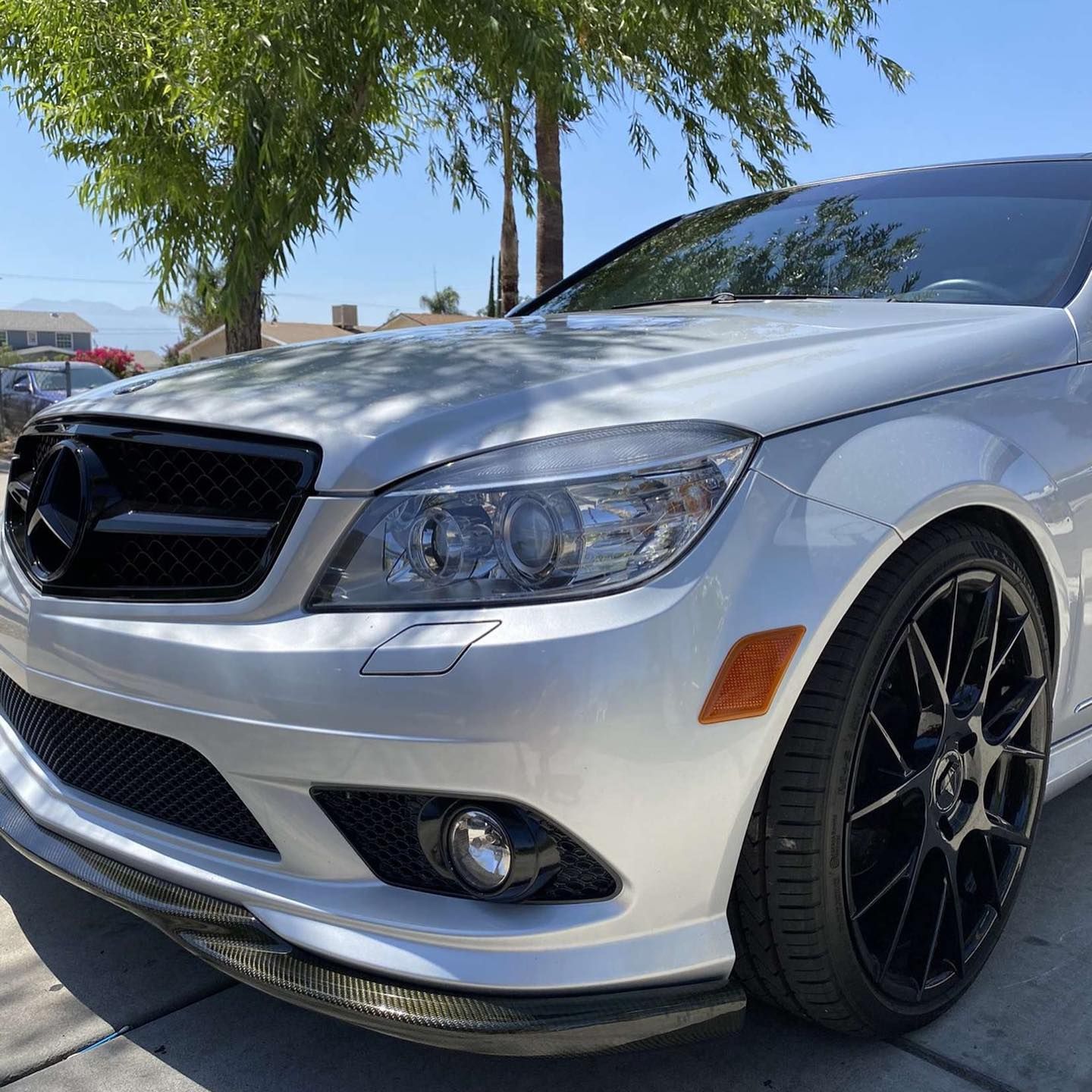 A silver mercedes benz is parked on the side of the road