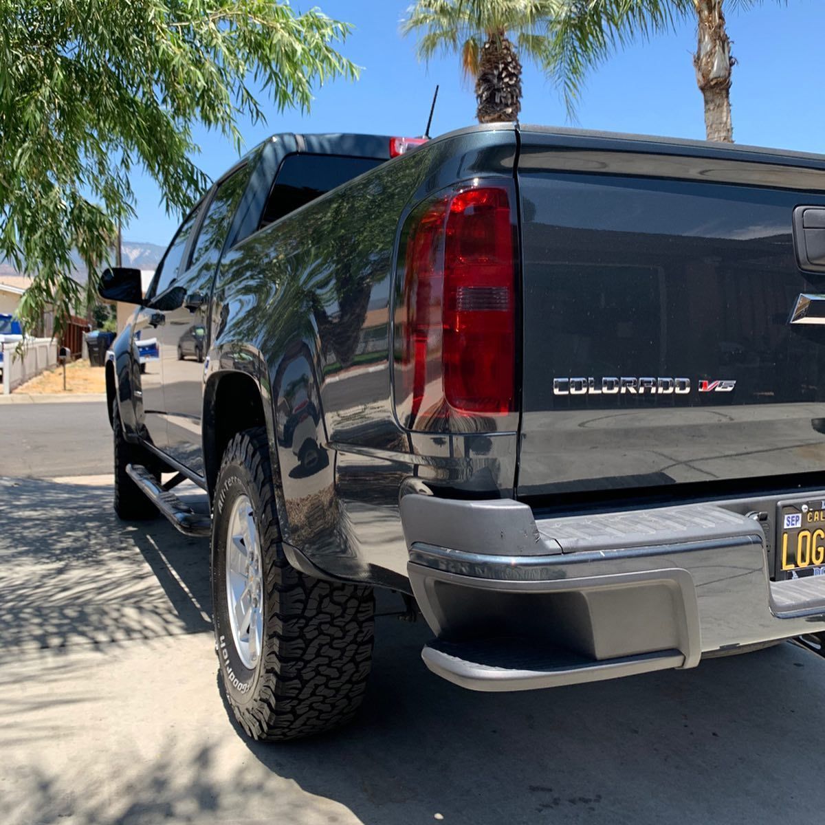 A black colorado truck is parked on the side of the road