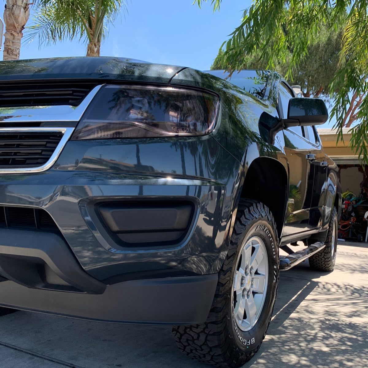 A black truck is parked in front of a garage.