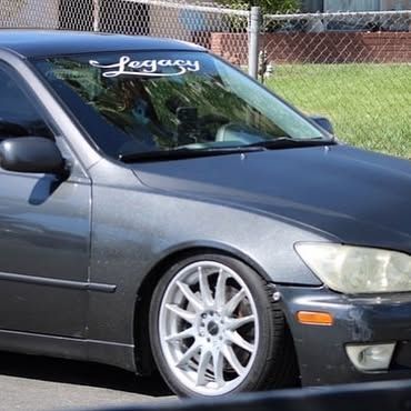 A black car with a legacy sticker on the windshield