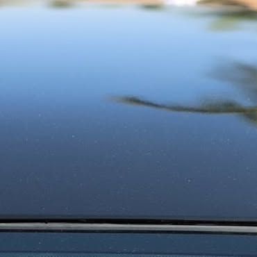 A close up of the hood of a black car.