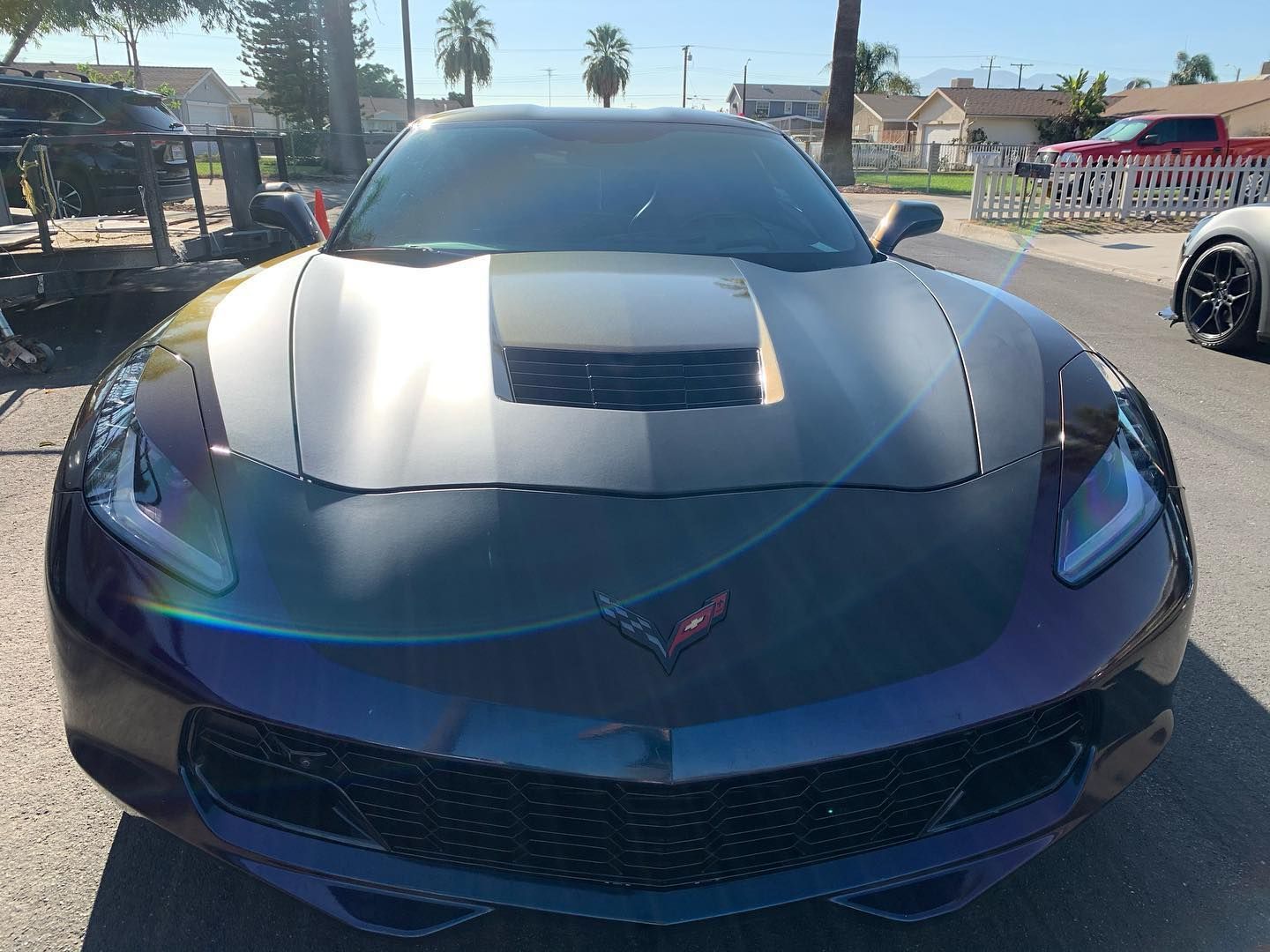 A purple sports car is parked on the side of the road.