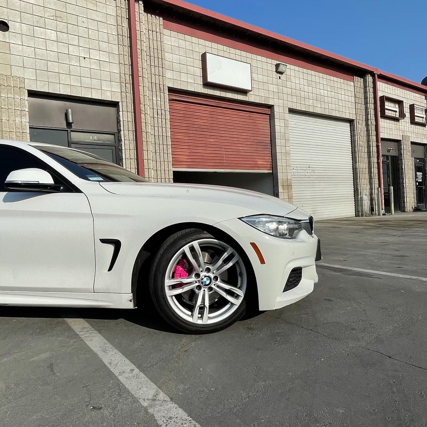 A white car with the number 7 on the side is parked in front of a building