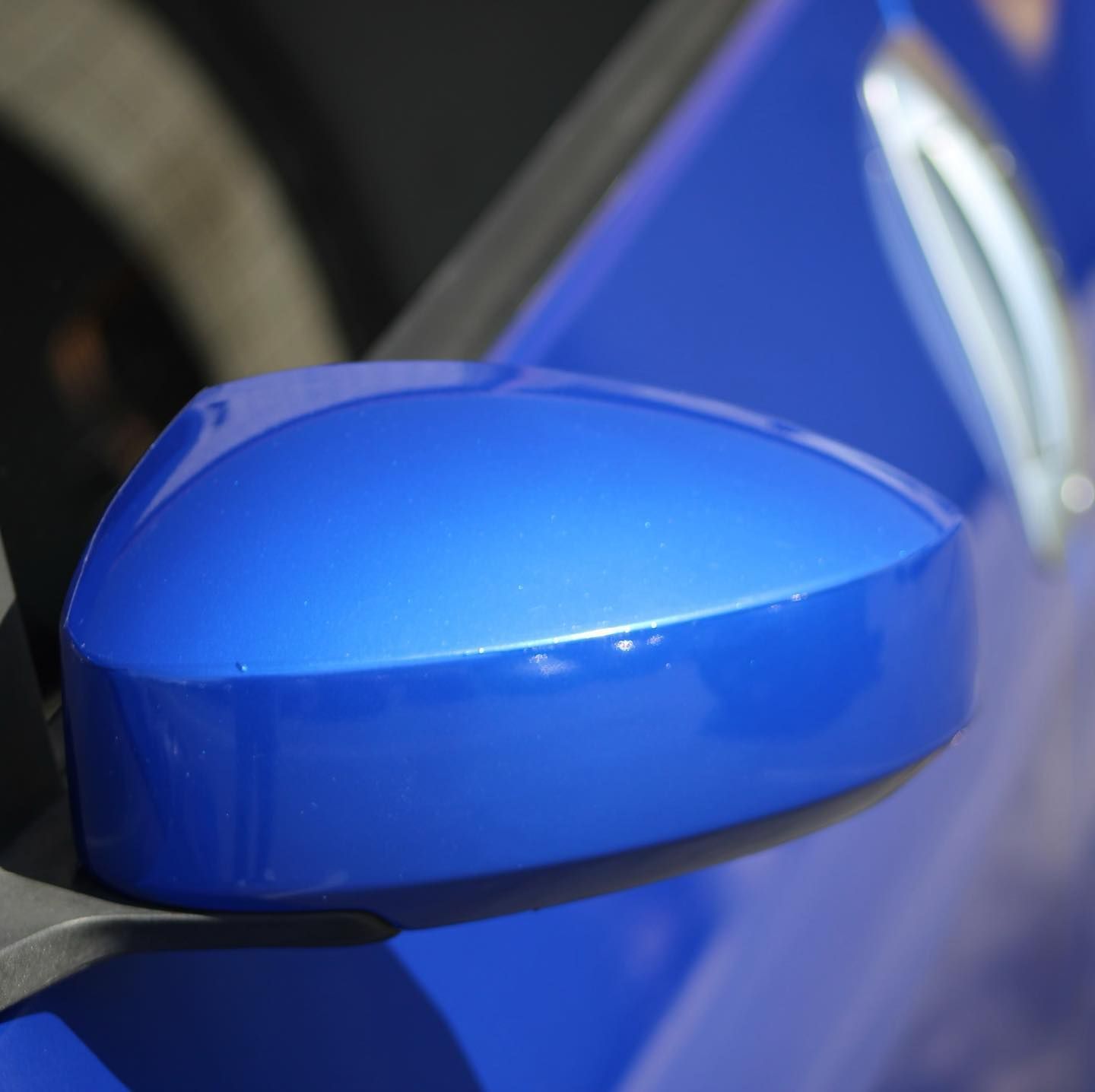 A close up of a blue car 's side mirror