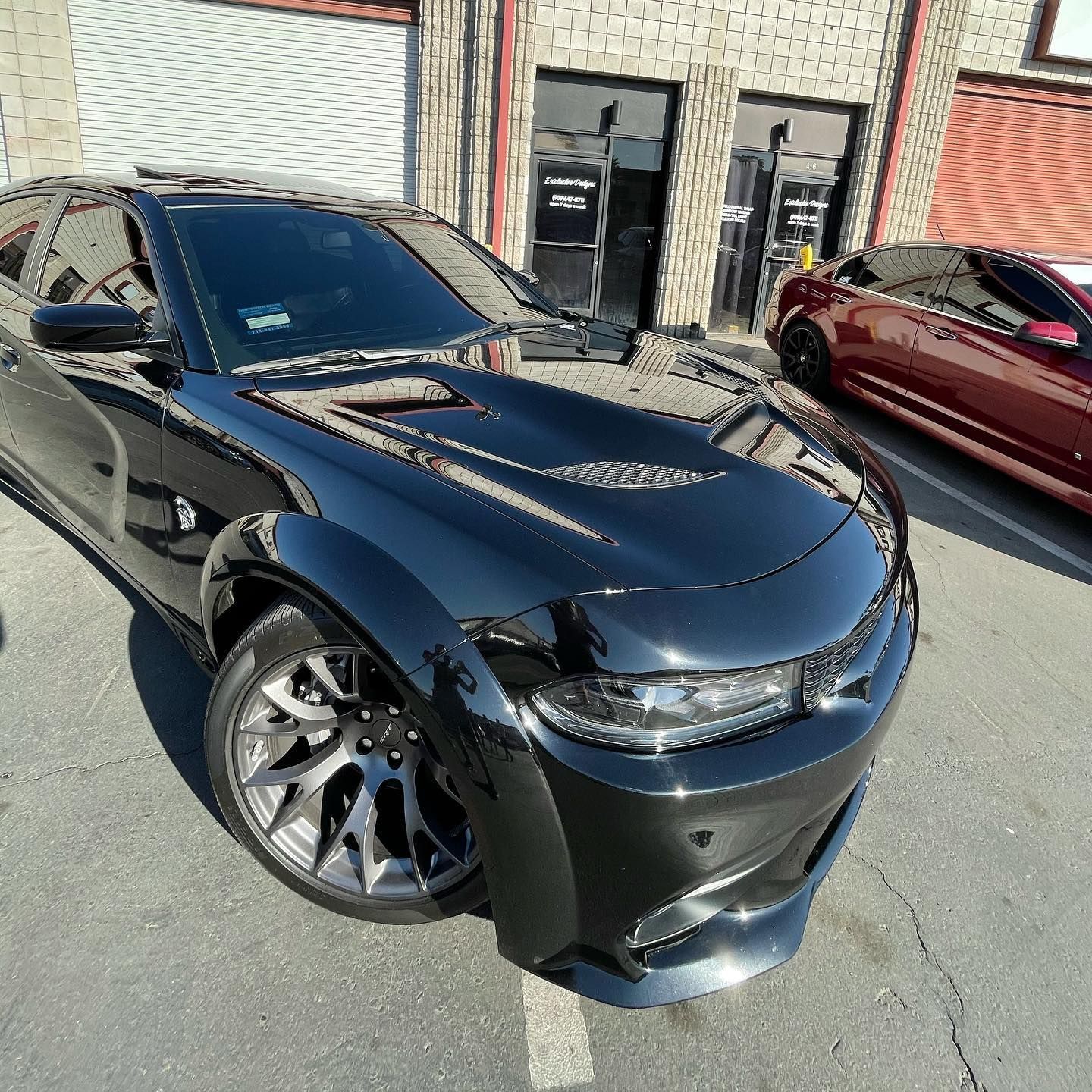 A black car is parked in front of a building