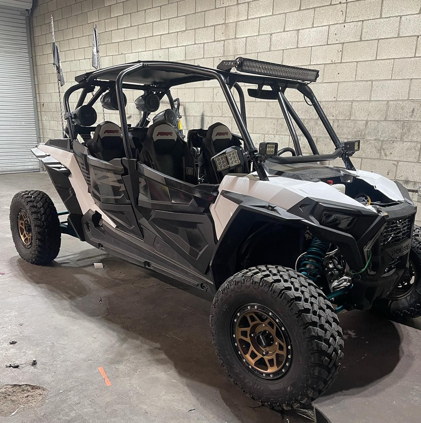 A black and white atv is parked in a garage next to a brick wall.