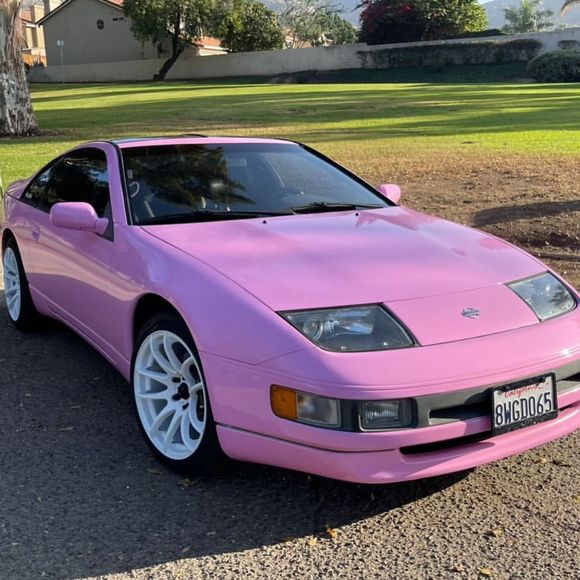 A pink car with a license plate that says sxc065