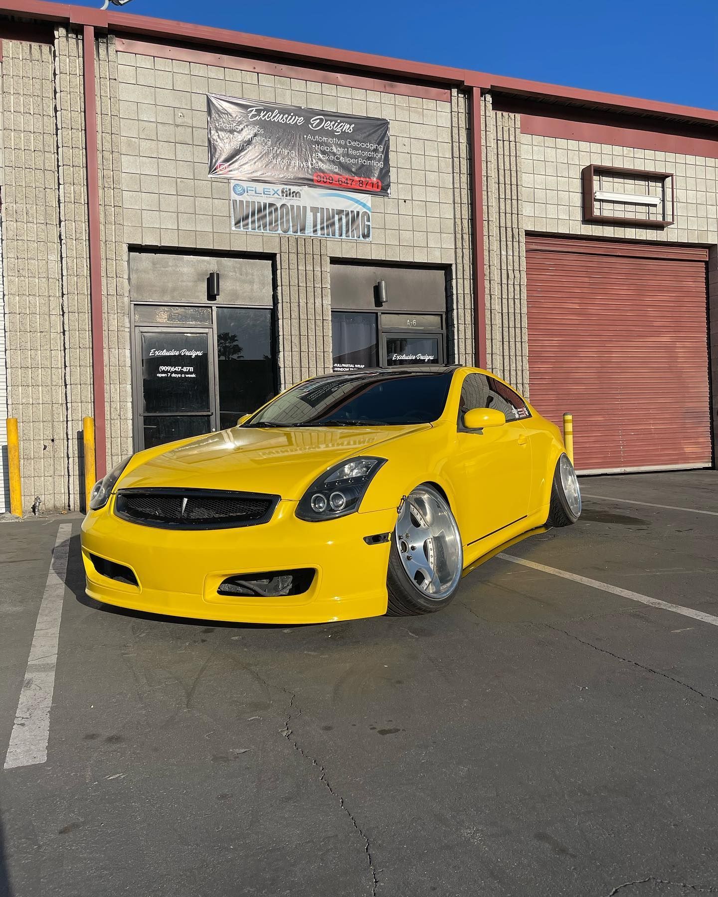 A yellow car is parked in front of a building.