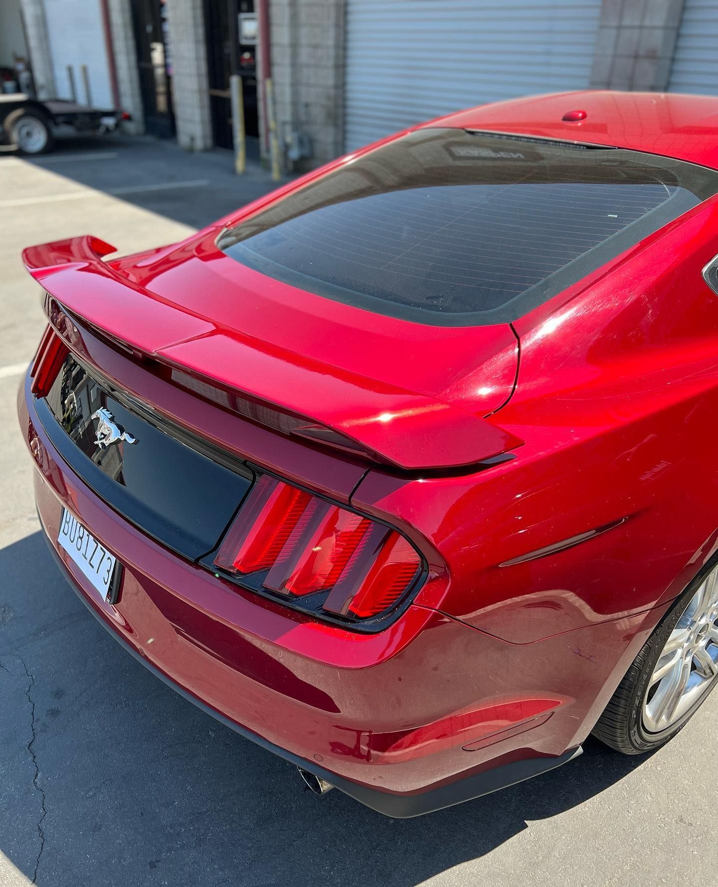 A red ford mustang is parked in a parking lot.