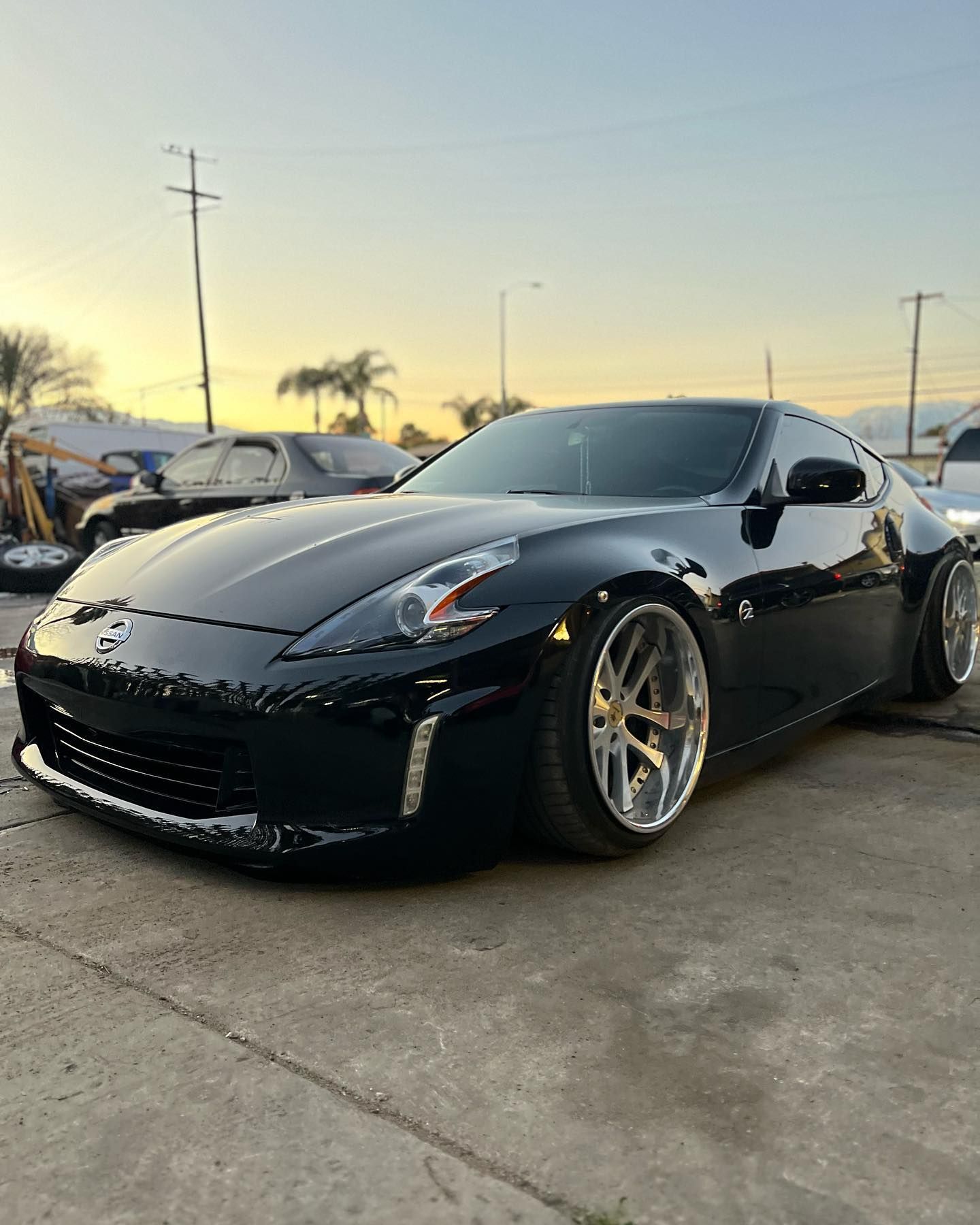 A black sports car is parked in a parking lot.