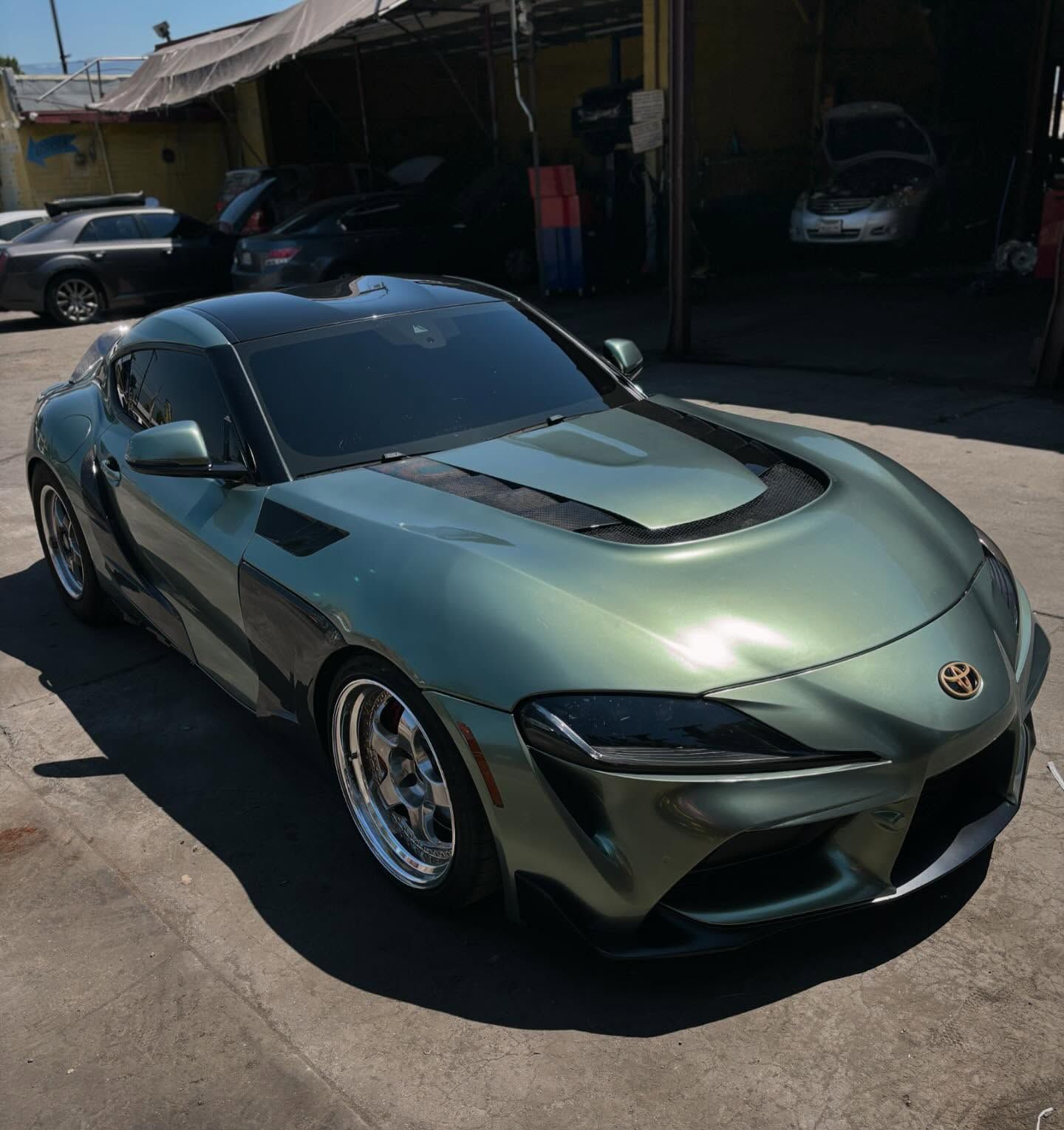 A green sports car is parked in a parking lot