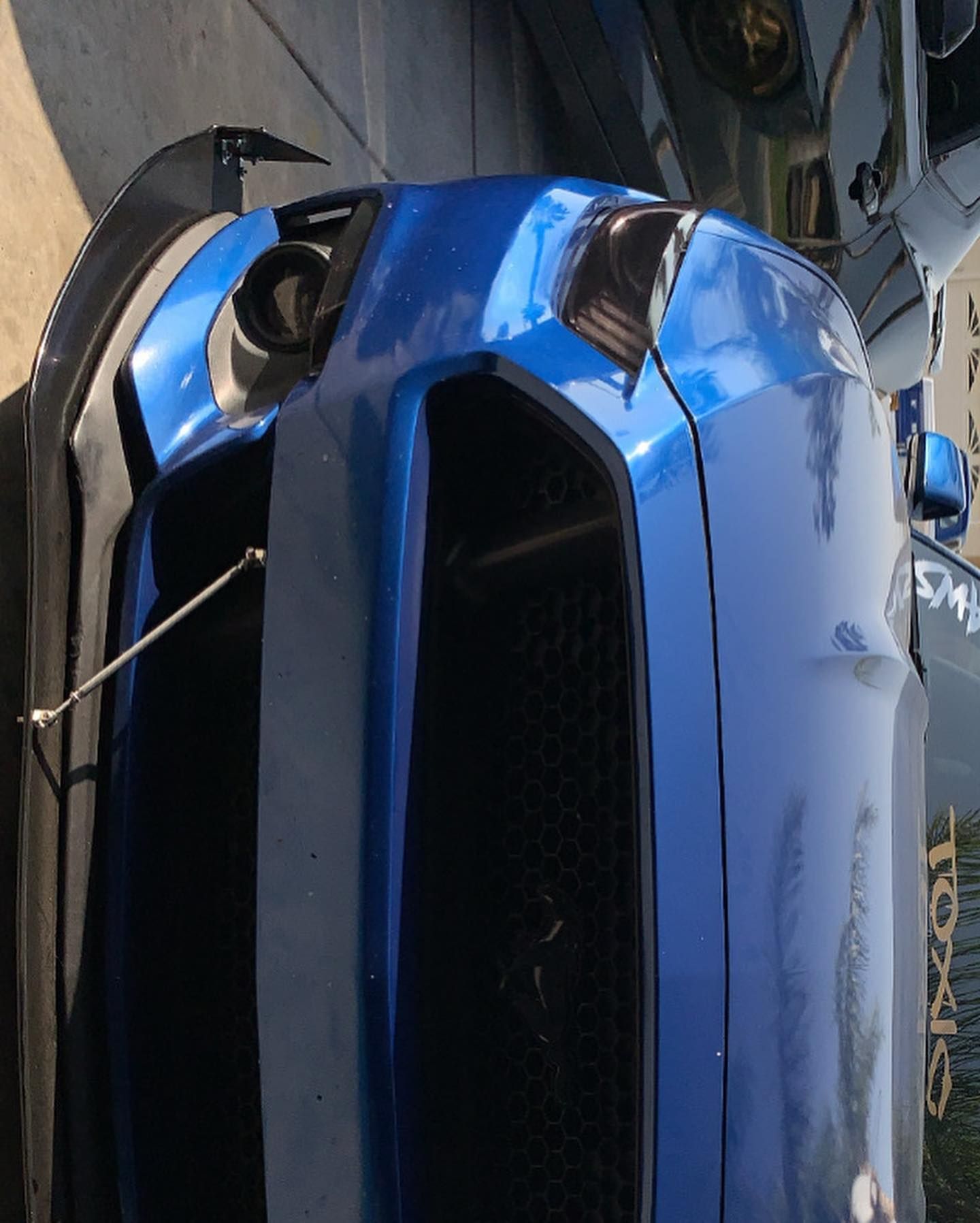A blue car that has been turned on its side