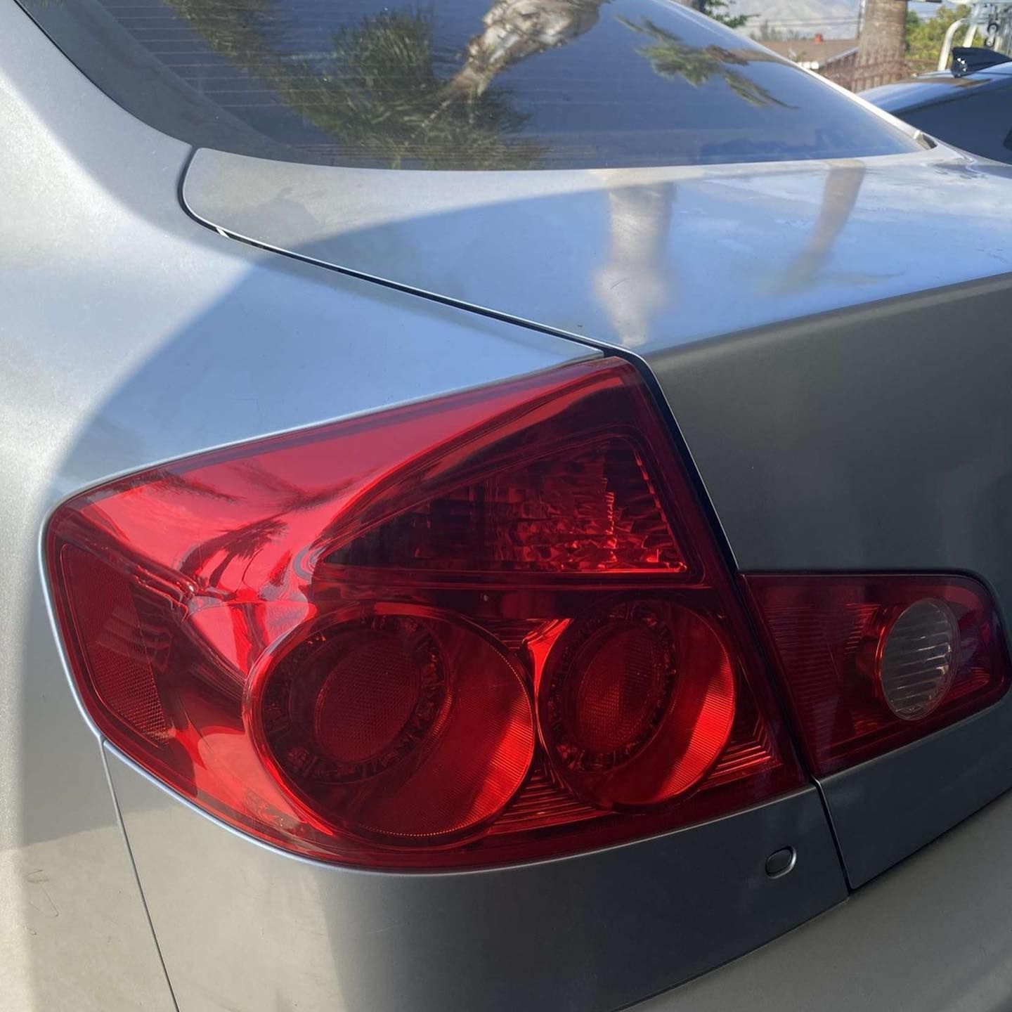 A silver car with a red tail light