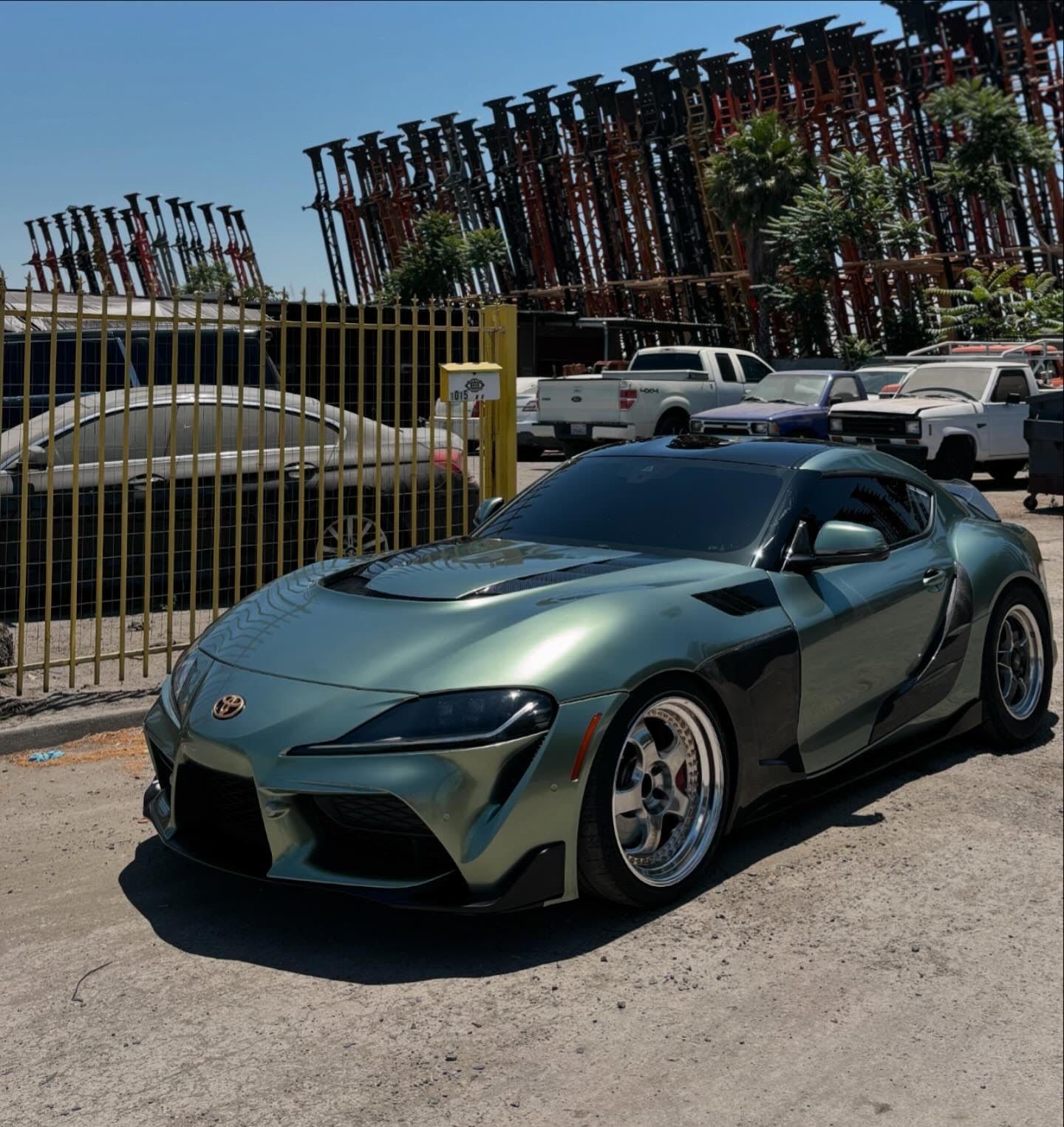 A green sports car is parked in a parking lot