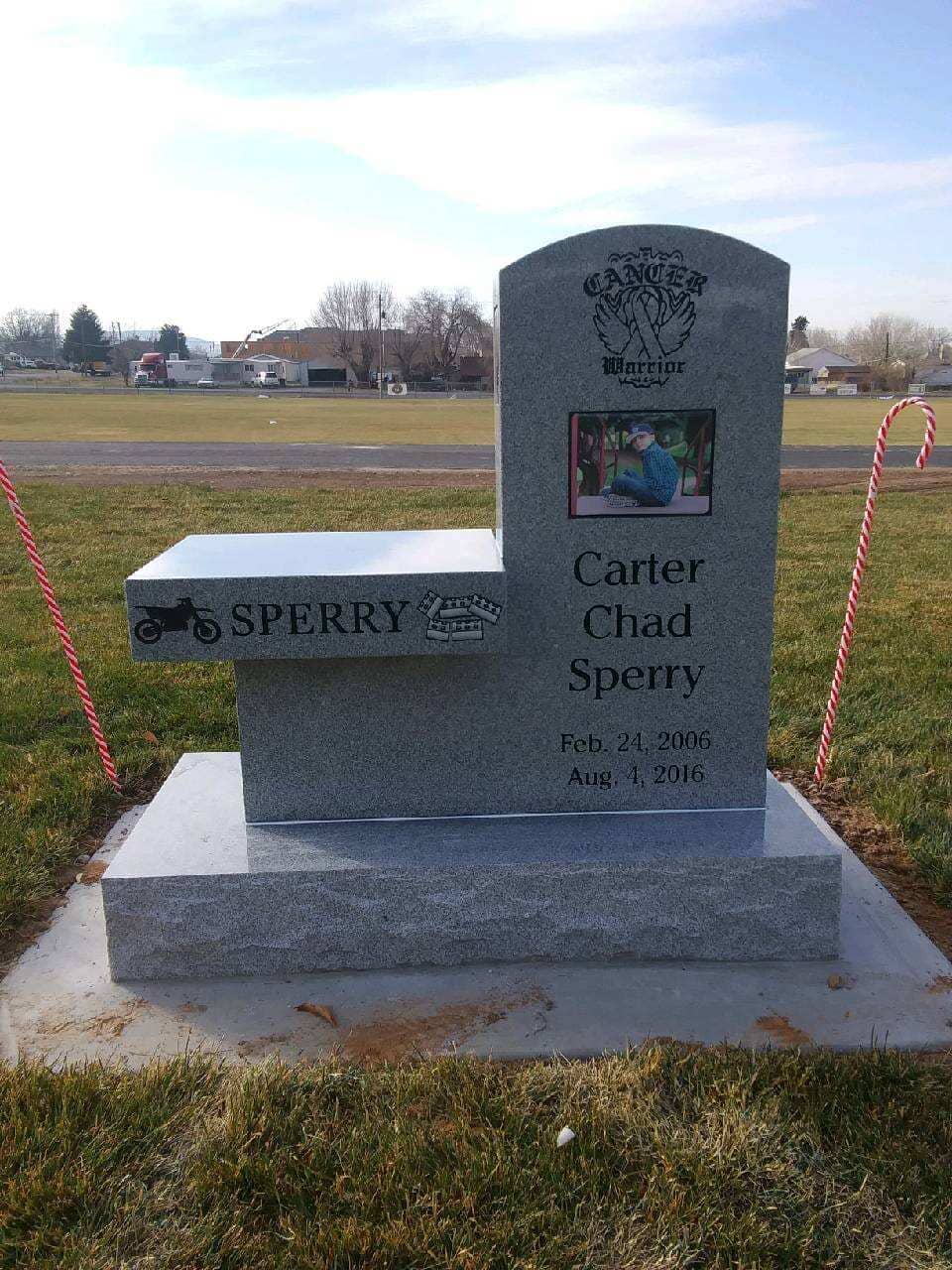 Grave marker with bench for Carter Chad Sperry: includes a photo, motorcycle, and birth/death dates, with candy cane decorations.