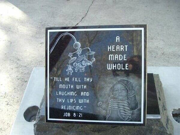 Black granite tombstone with engraved text: 