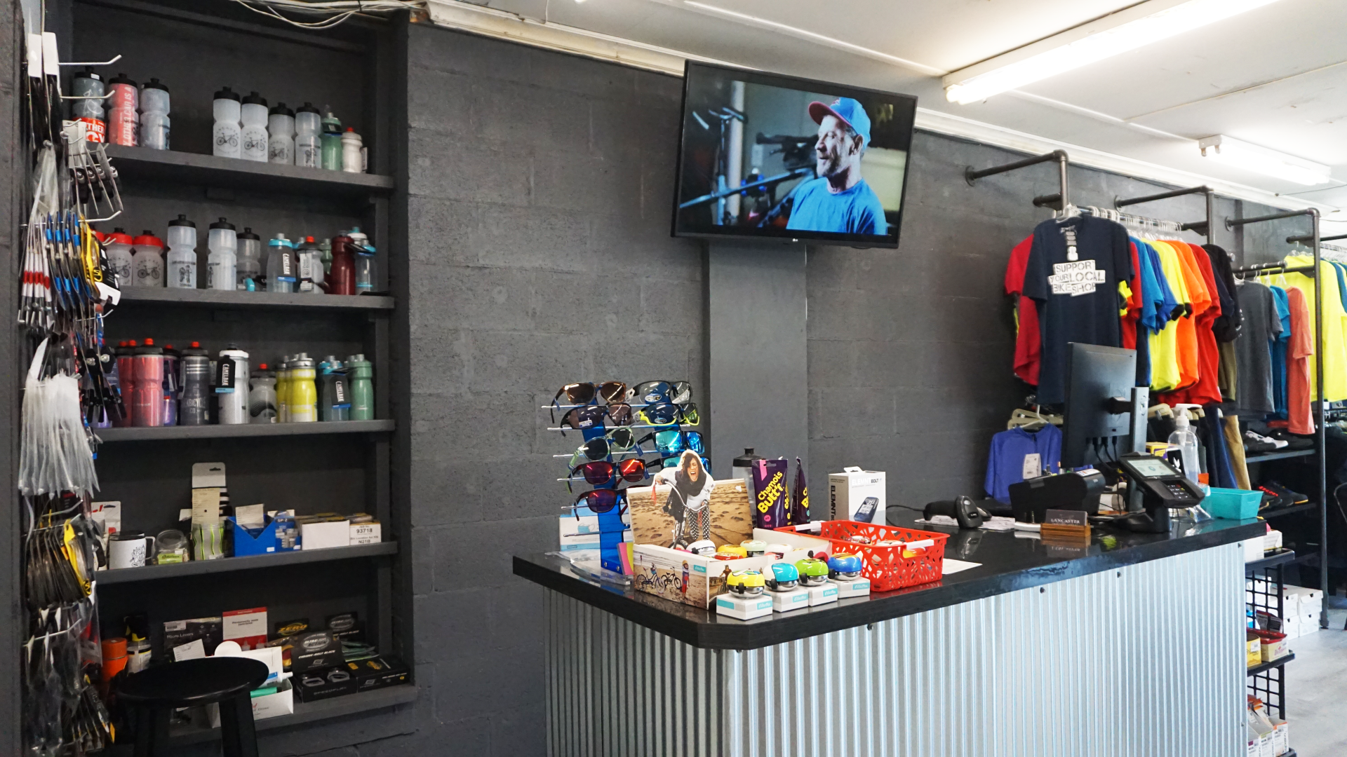 A store with a counter and a television on the wall.