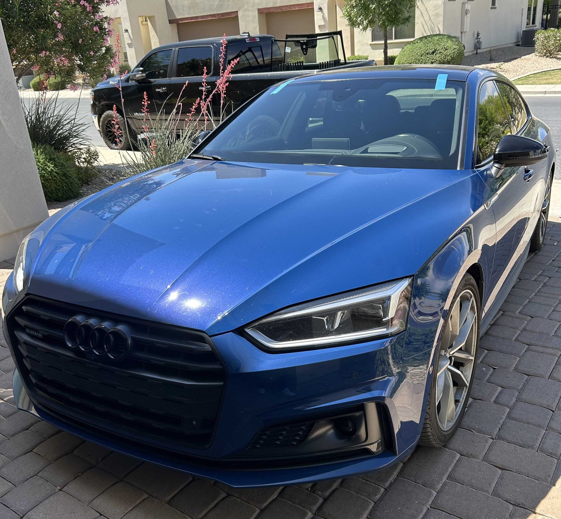 Windshield replacement on an Audi with an auto glass technician's truck with windshields in the background.