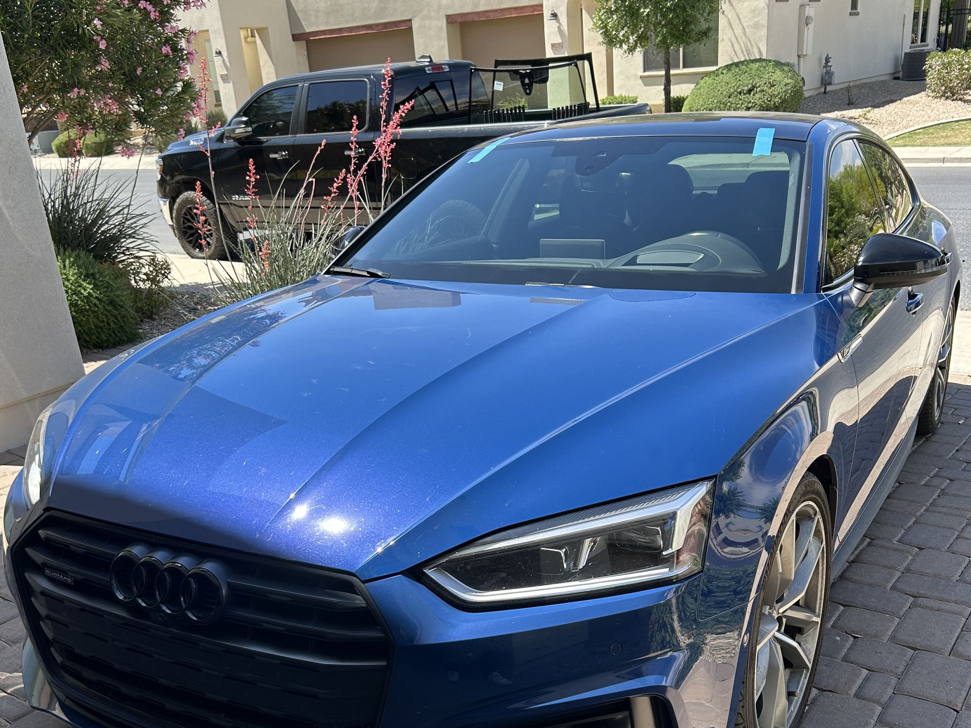 Windshield replacement on an Audi with an auto glass technician's truck with windshields in the background.