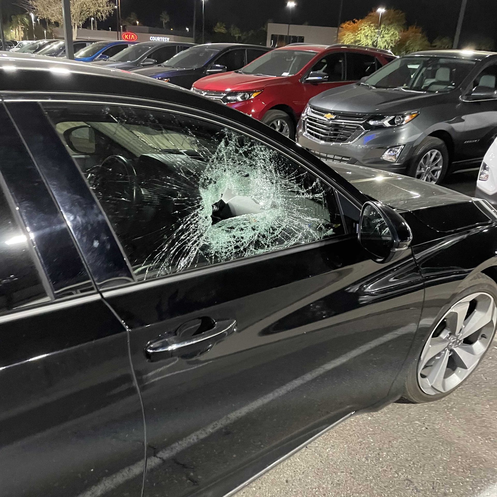 Auto glass replacement of broken door glass on a black vehicle.