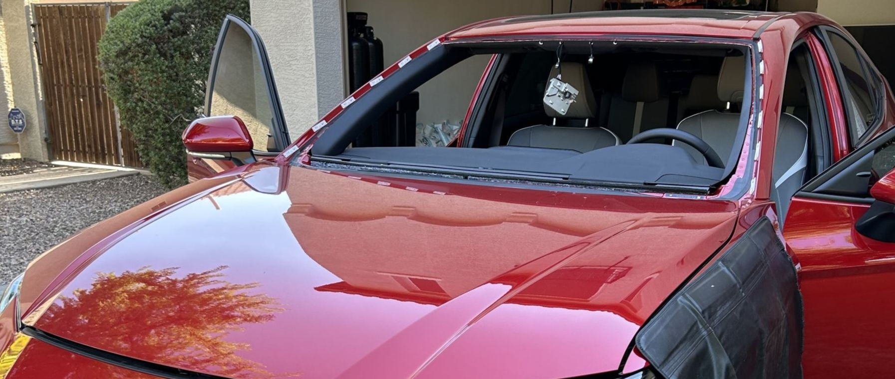 Red car with the windshield removed and the ADAS camera removed.