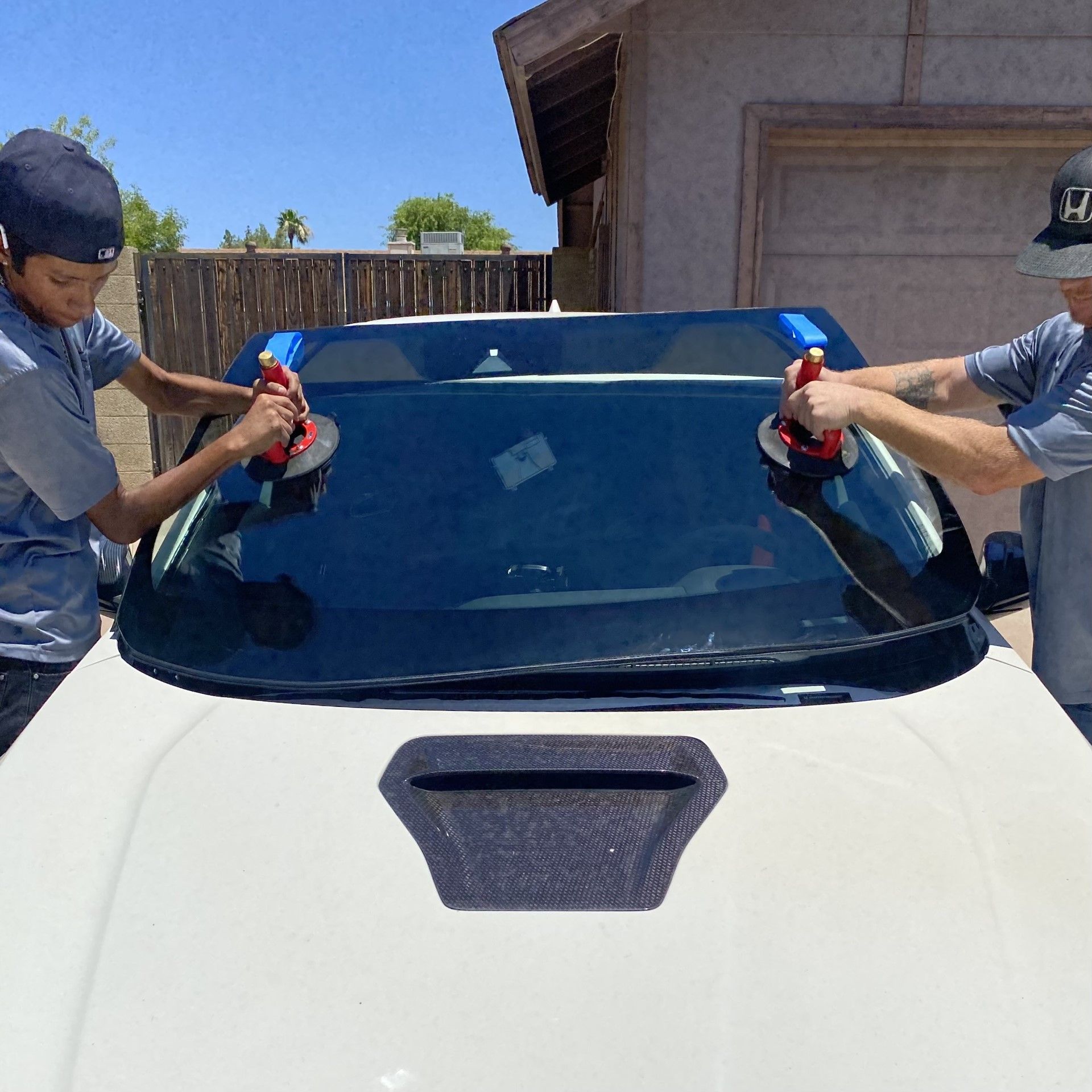 Auto glass installers replacing a windshield on a white Honda Civic Type-R in Mesa, AZ.