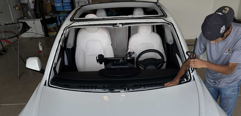Windshield removed before a windshield replacement on a white Tesla.