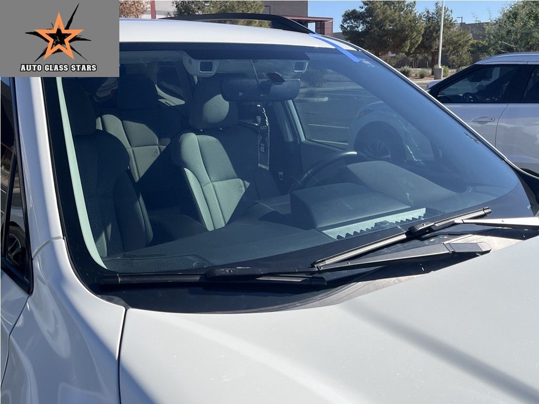 White vehicle with a newly replaced windshield.
