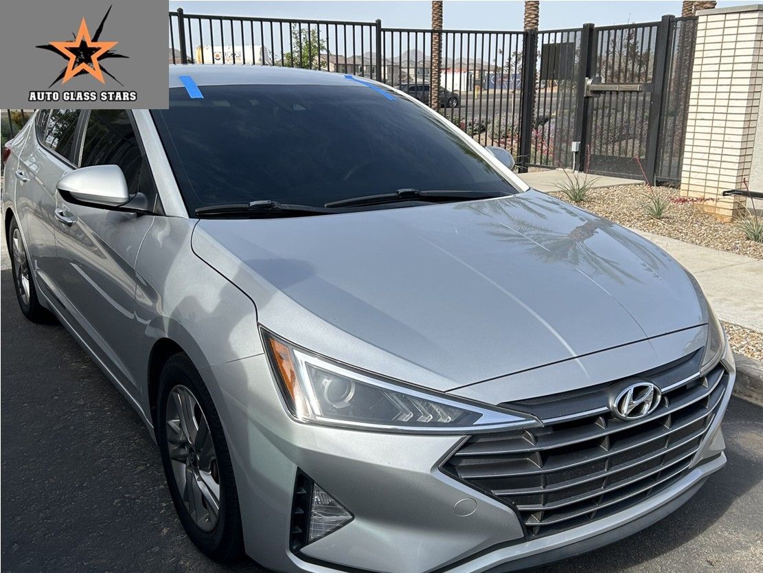 Tinted windshield replacement with blue tape to hold it front shifting on the Hyundai.
