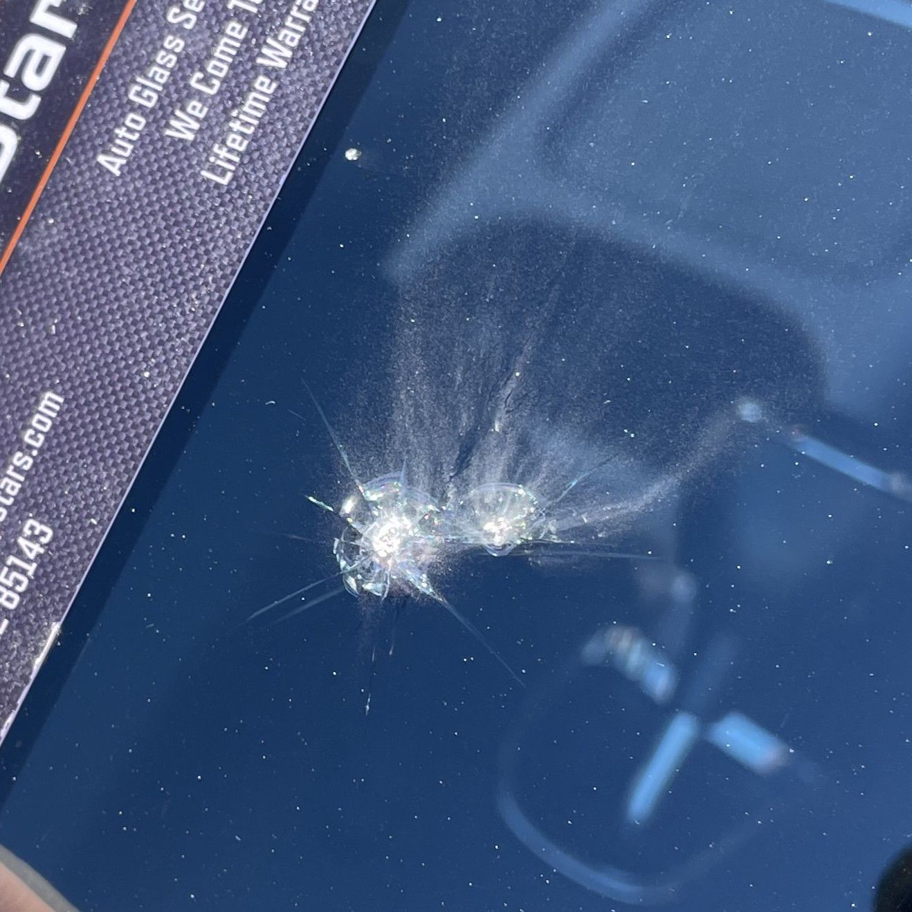 Windshield with a star-shaped crack, damage from impact.