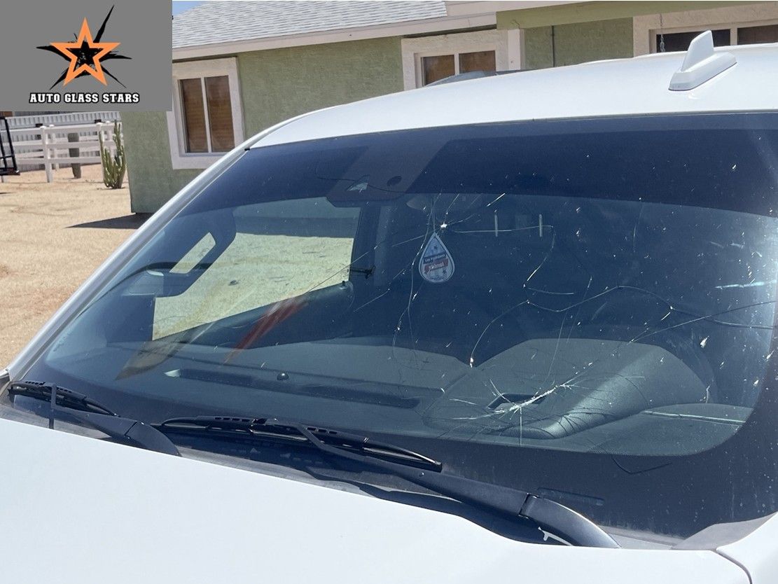 White truck windshield with cracks before replacement.