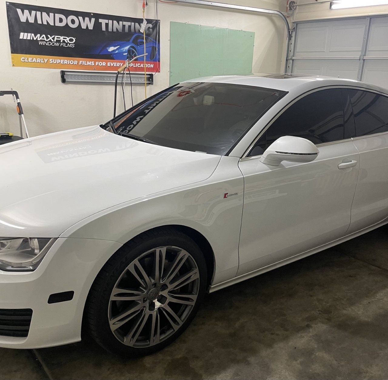 White Audi with a dark tinted windshield and windows.