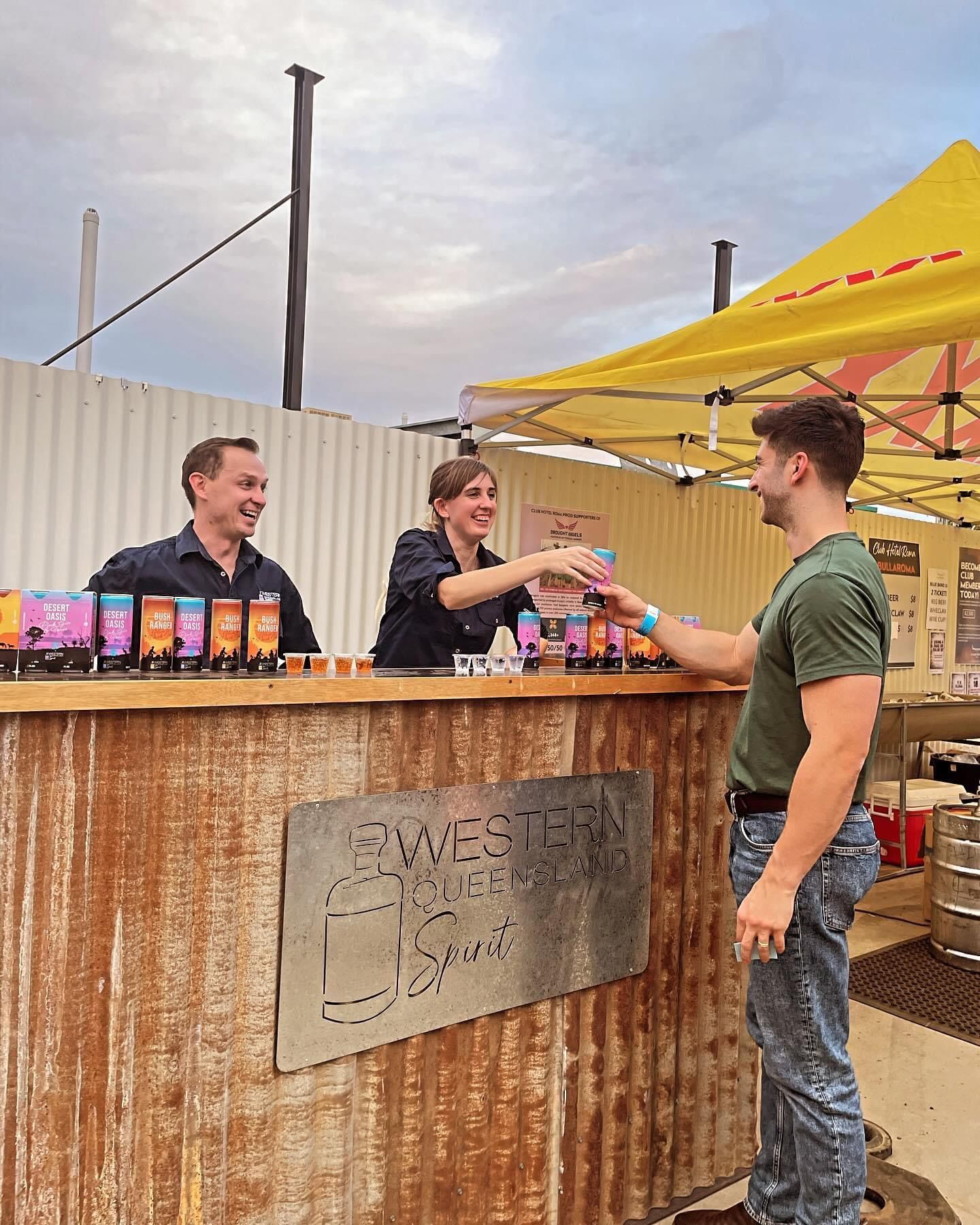A man purchases a premixed Western Queensland Spirit can from a pop up bar.