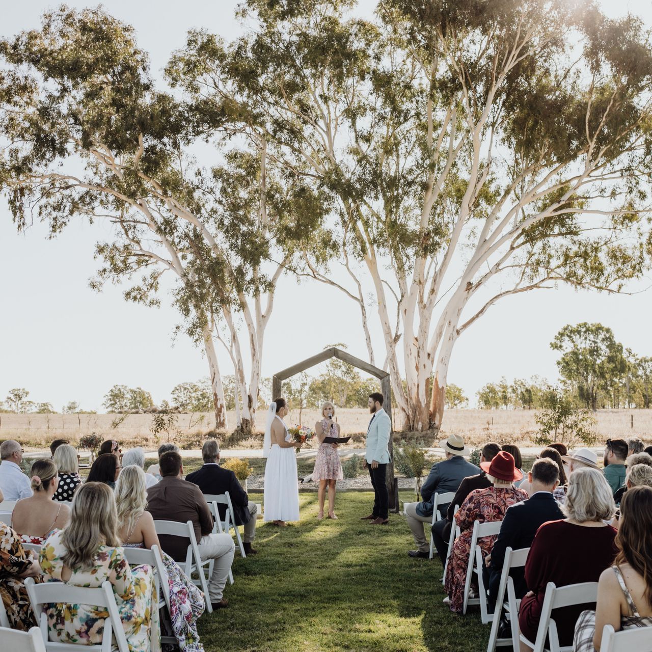 A group of people are sitting in folding chairs at a wedding ceremony.