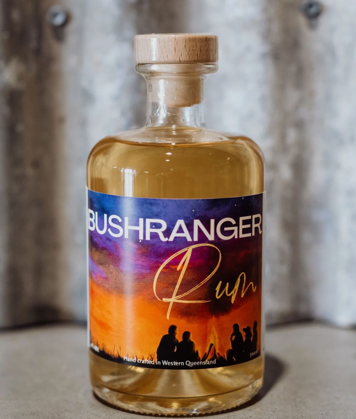 a bottle of bushranger rum is sitting on a concrete surface .