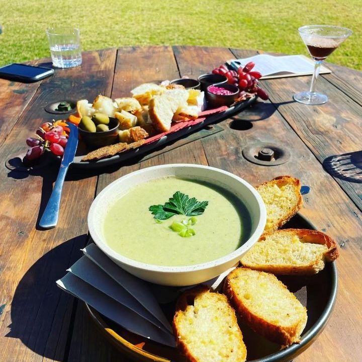 A bowl of soup and bread on a wooden table