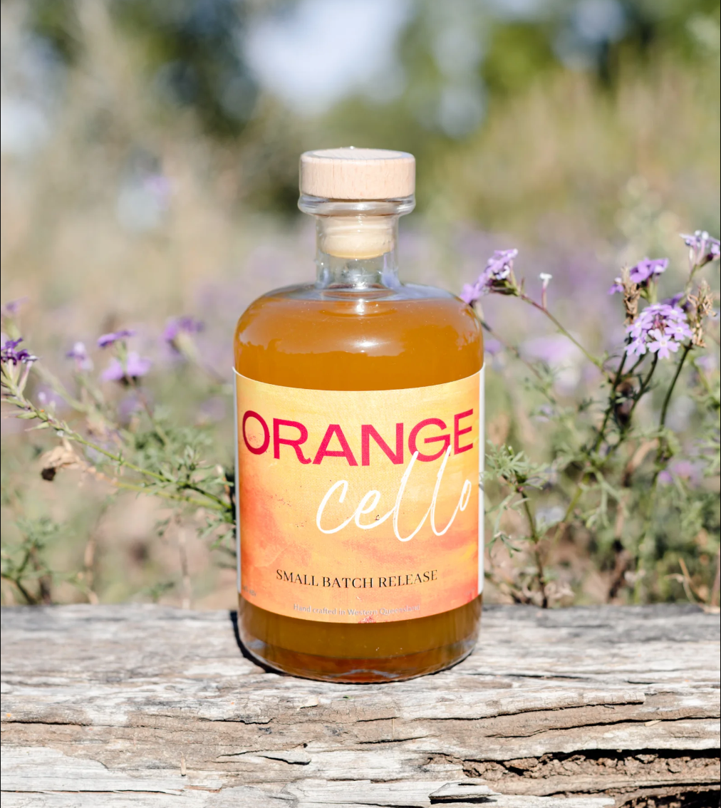 a bottle of orange cell is sitting on a piece of wood .