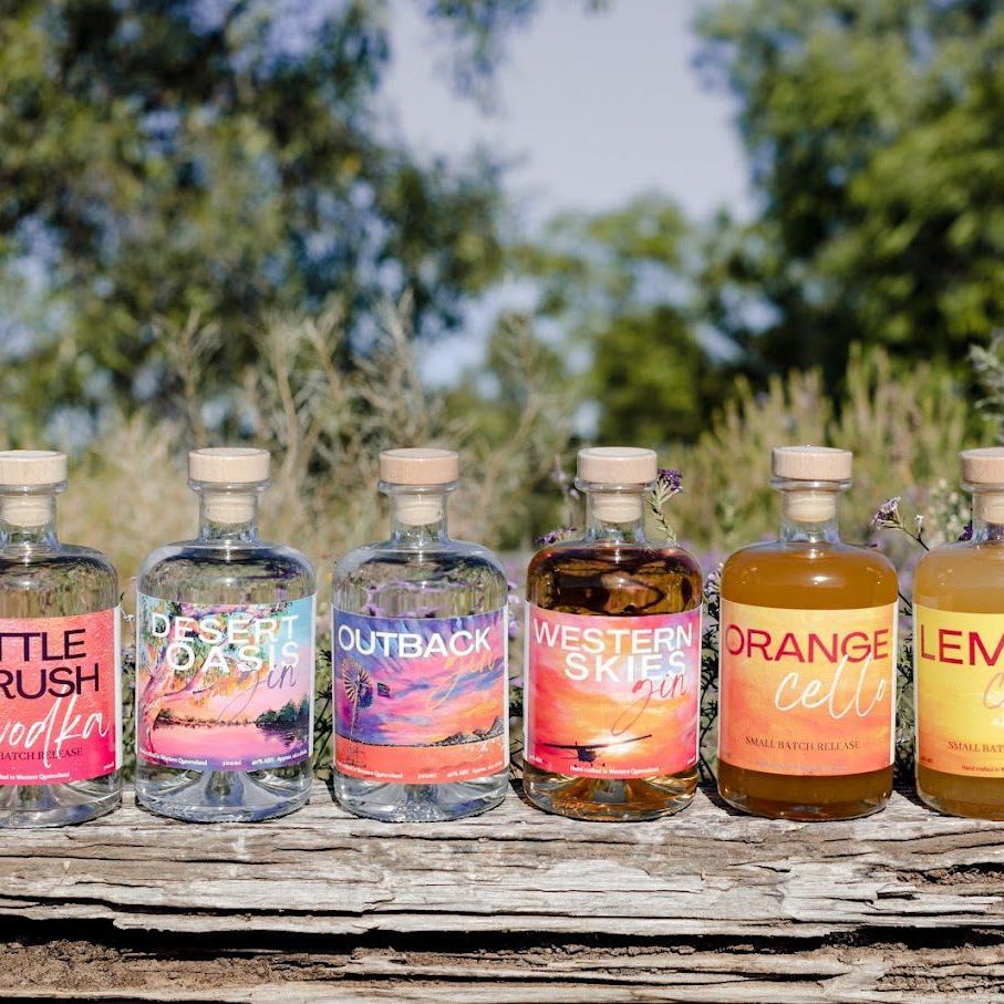 A line up of spirit bottles sitting on a log.