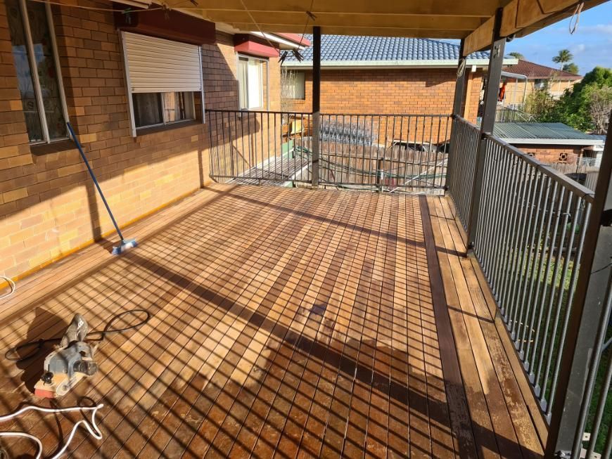 A Wooden Deck With A Metal Railing And A Brick Building In The Background — Paint & Trade Supplies Lismore In Goonellabah, NSW