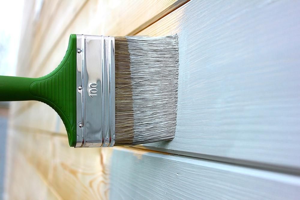 A Brush Is Being Used To Paint A Wooden Wall — Paint & Trade Supplies Lismore In Byron Bay, NSW