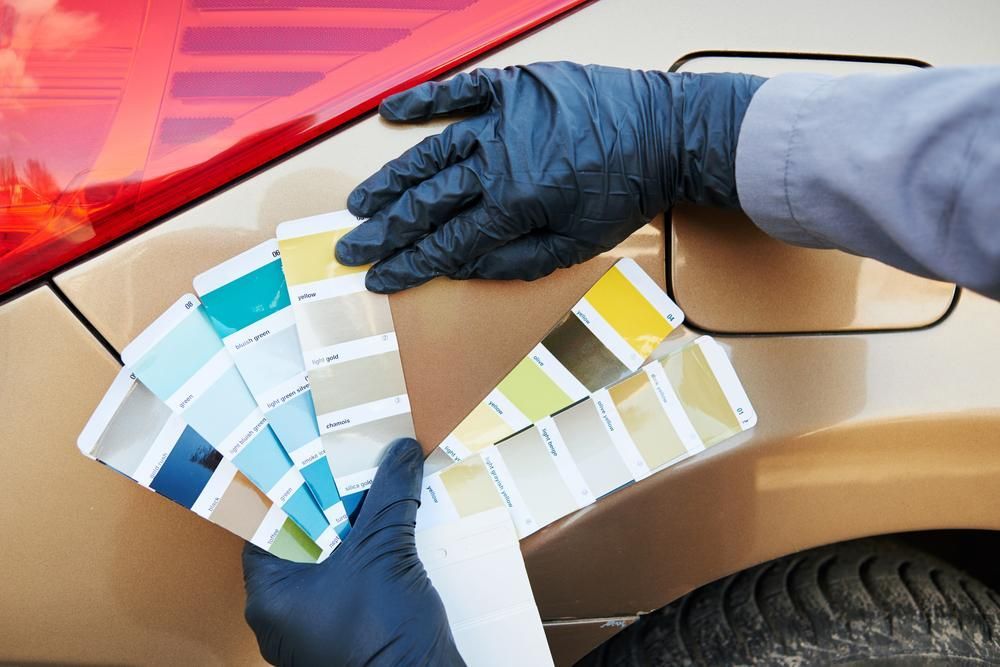A Person Is Holding A Color Palette In Front Of A Car — Paint & Trade Supplies Lismore In Goonellabah, NSW
